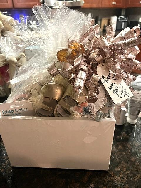 Baby gift box with tiny shoes and rose gold curly ribbon