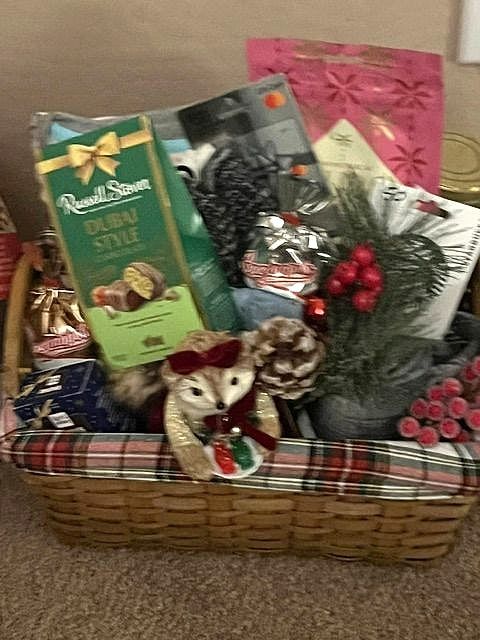 Plaid-lined basket with chocolates, a plush owl, pinecones and berries