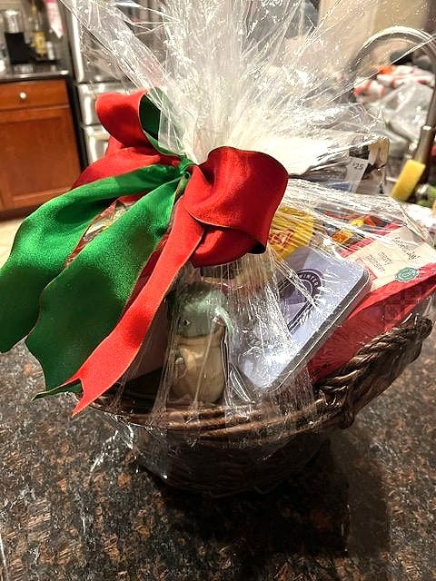 Christmas basket wrapped in cellophane with red and green satin bows