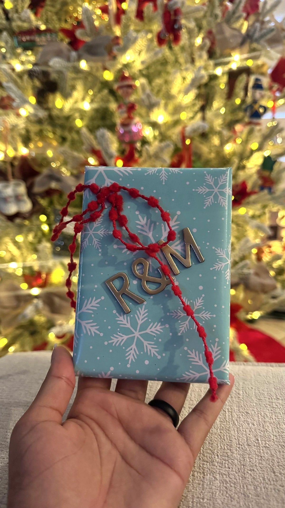 Present in light blue snowflake paper with a red bead garland and silver initials