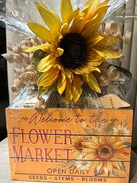 Gift basket in a 'Welcome to the Flower Market' wooden crate, topped with a big sunflower and curled ribbon
